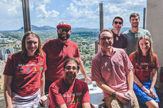 A group of students gather in front of a window in Greece.
